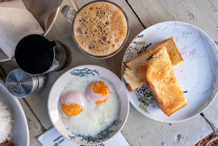 A traditional Malaysian breakfast with coffee, eggs and kaya toast.