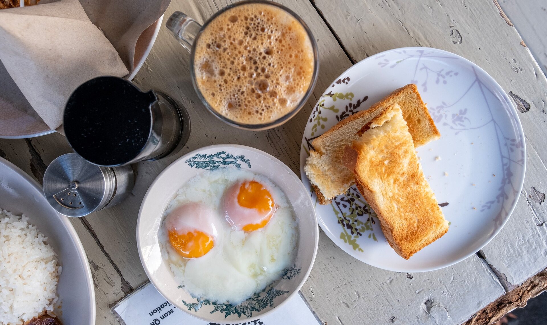 A traditional Malaysian breakfast with coffee, eggs and kaya toast.