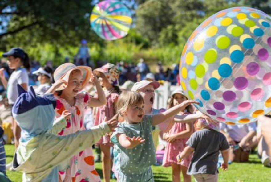 Group of children playing with large inflatable balls.