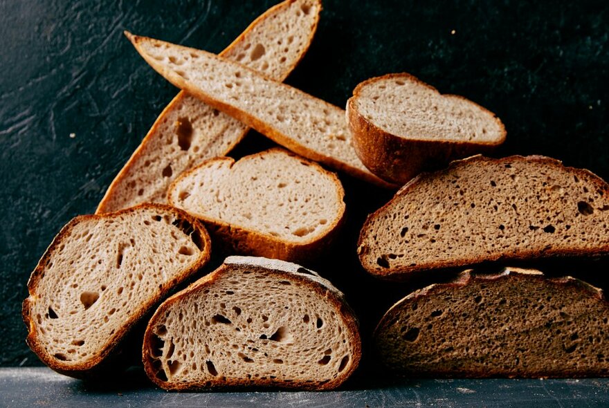 Assorted breads, all cut open with the crumb visible. 