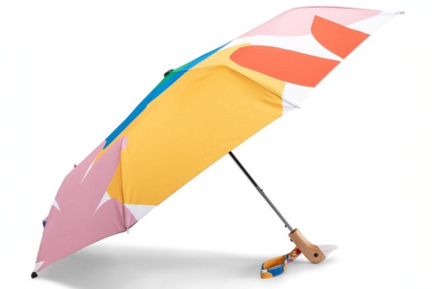 A colourful umbrella with a duck head shaped handle.