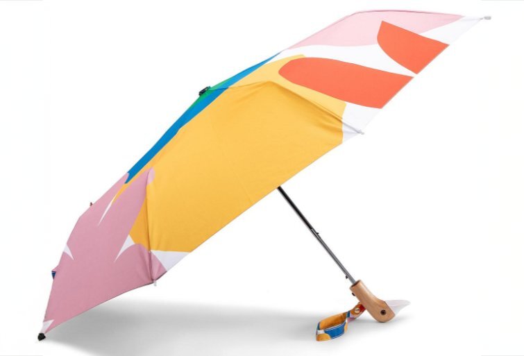 A colourful umbrella with a duck head shaped handle.