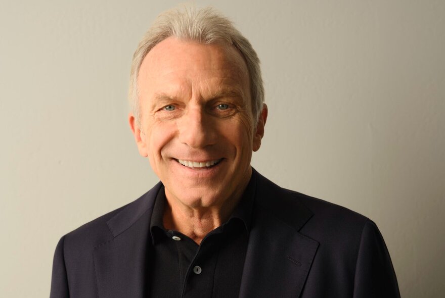 NFL legend Joe Montana, wearing dark suit and smiling.