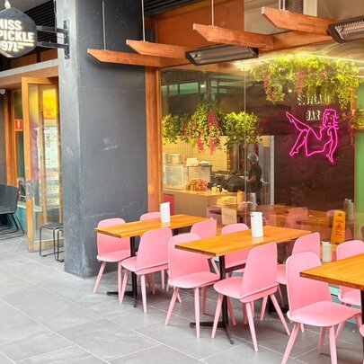 Pink dining chairs at tables outside Miss Pickle.