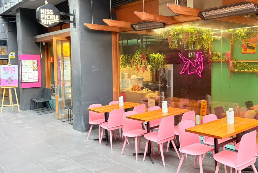 Pink dining chairs at tables outside Miss Pickle.