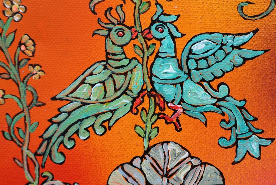 Detail of Indian artwork with blue birds and orange background.