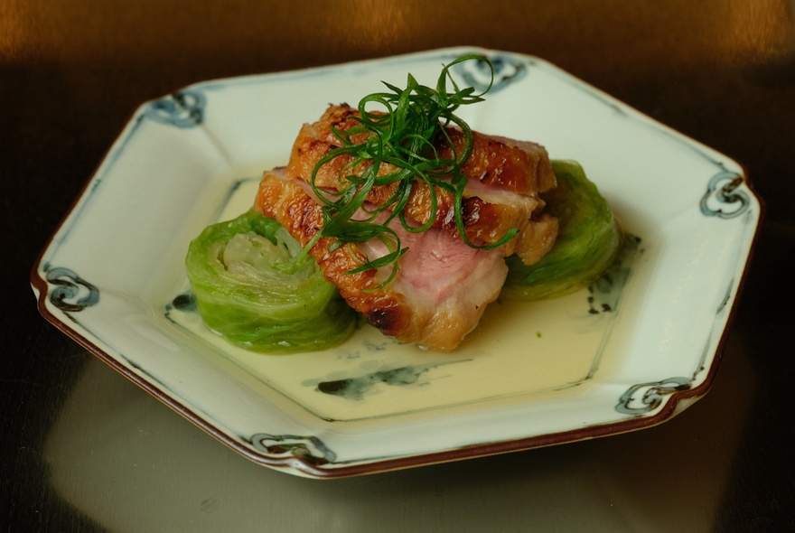 Dish of meat and vegetables with garnish.