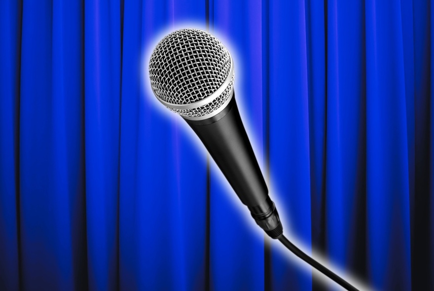 An microphone against a vivid blue curtain.