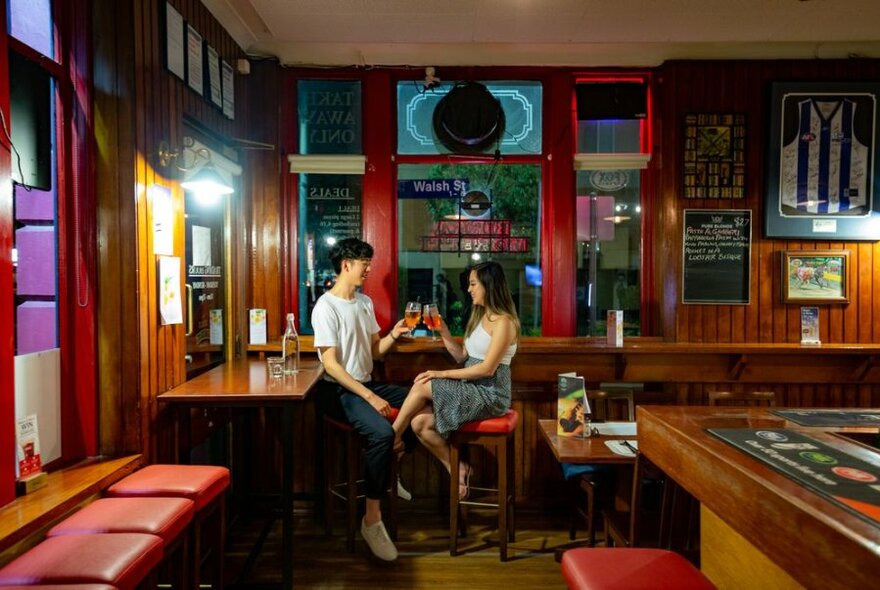 Two people enjoying drinks in a pub.