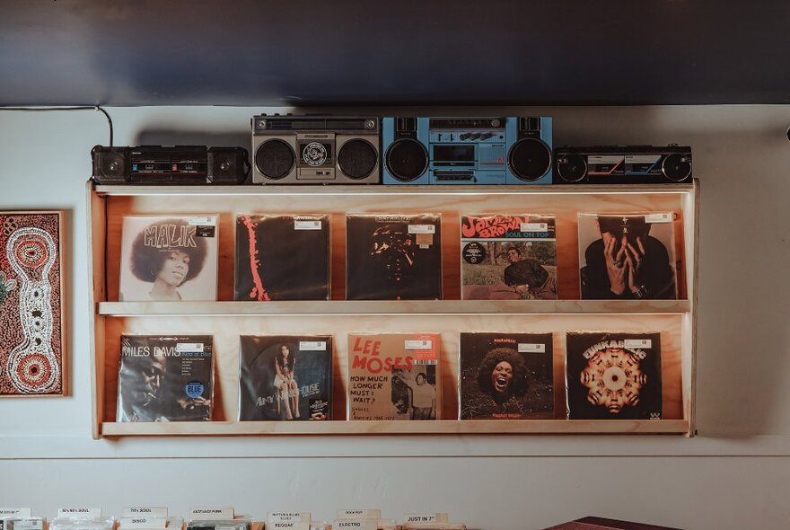 A shelf displaying records and boom boxes.