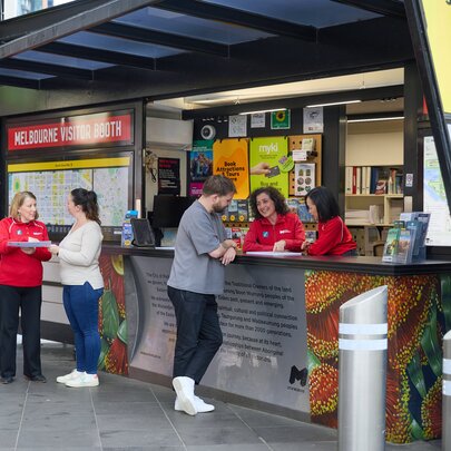 People getting help from red-shirted staff at the Melbourne Visitor Booth. 