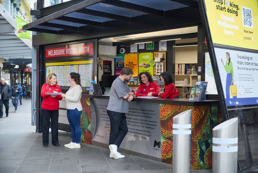 People getting help from red-shirted staff at the Melbourne Visitor Booth. 