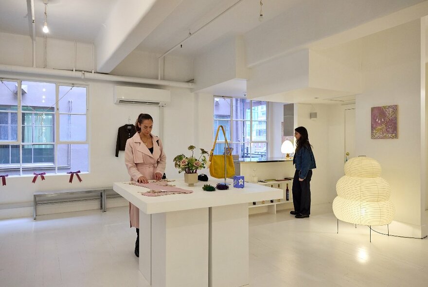 Two women are looking at items in a gift and clothing store. 