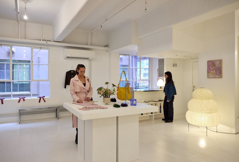 Two women are looking at items in a gift and clothing store. 