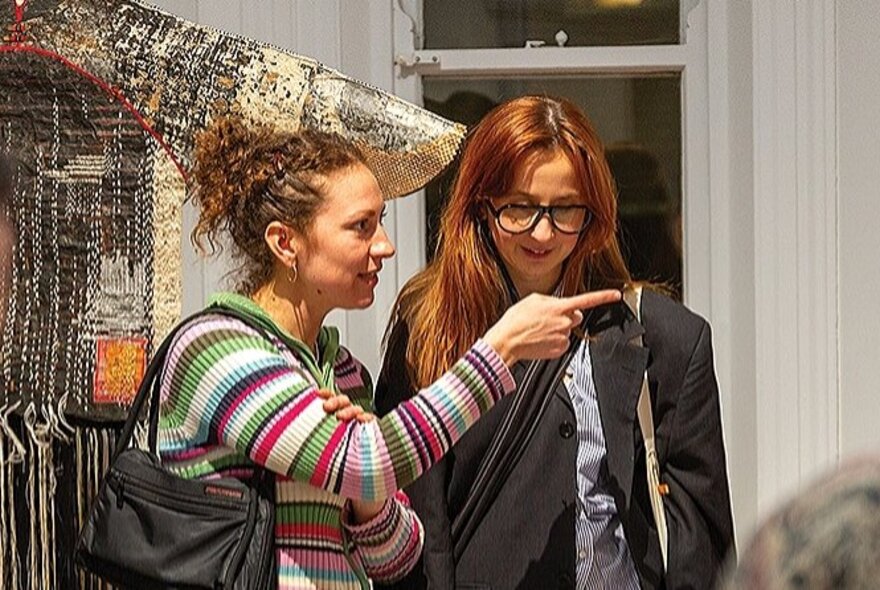 People looking at objects in a gallery space.