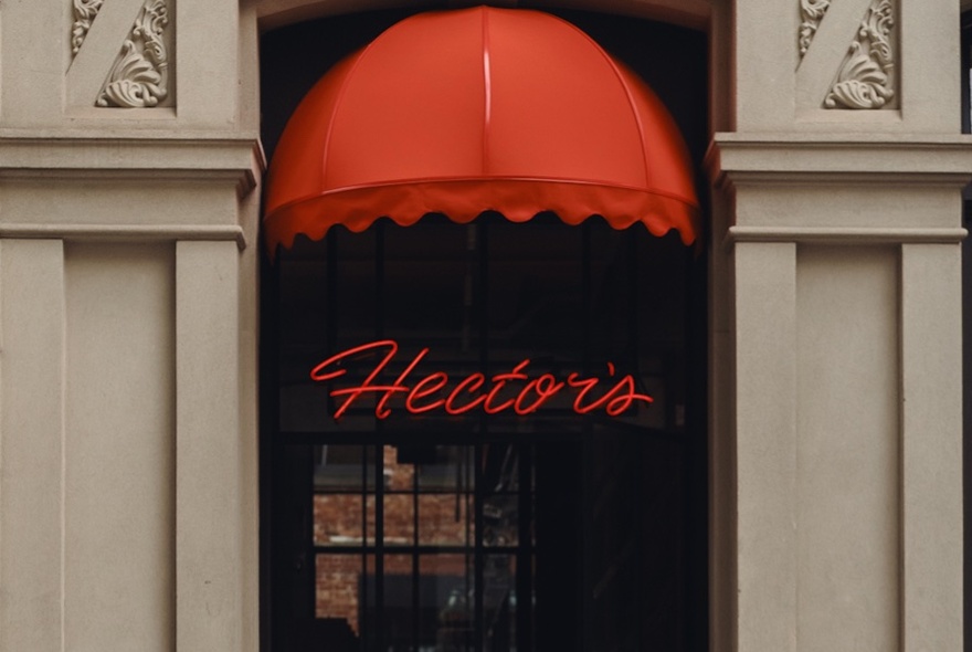 Red awning over a doorway framed by decorative stonework columns.