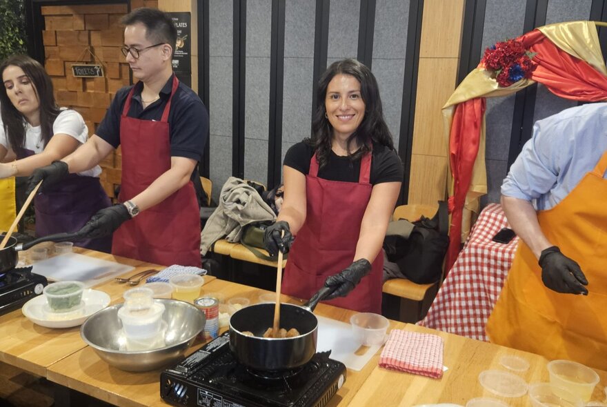 Participants cooking at tables with portable stoves and cooking implements.