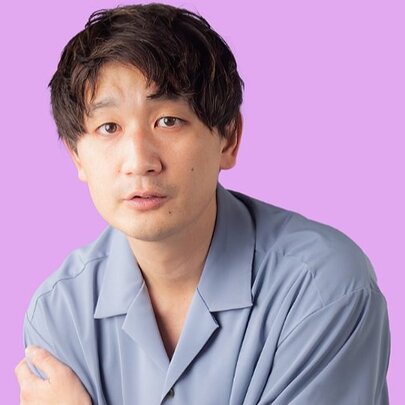 Japanese comic wearing a blue shirt.
