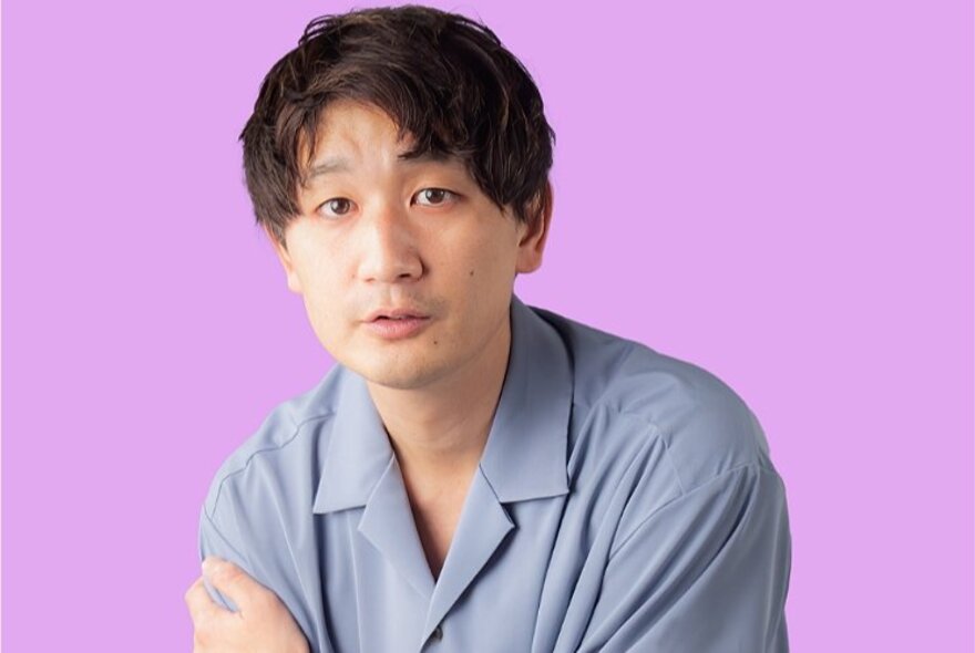 Japanese comic wearing a blue shirt.