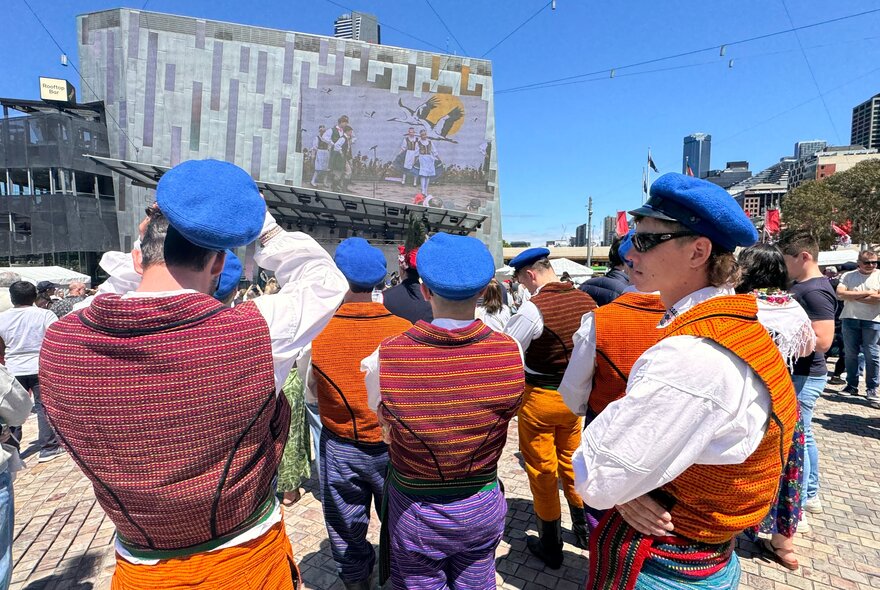 People wearing Polish cultural costumes, at the Polish Festival in the open plaza at Fed Square on a bright sunny day. 