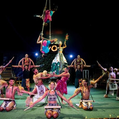 Performer on stage doing circus tricks, acrobats hanging in the air. 