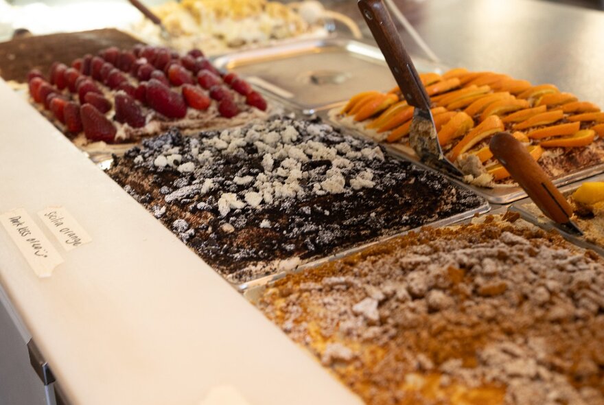 Serving trays of fruit desserts including nuts, berries and citrus.