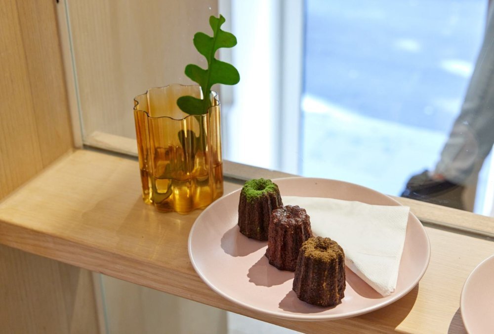 Wooden shelf with pink plate holding three caneles