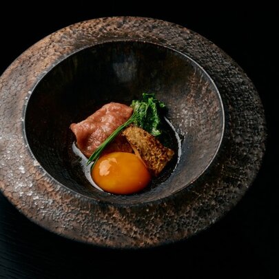 Japanese dish presented in a round stone bowl.