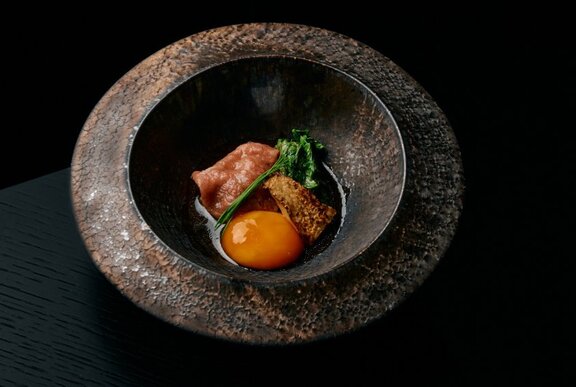 Japanese dish presented in a round stone bowl.