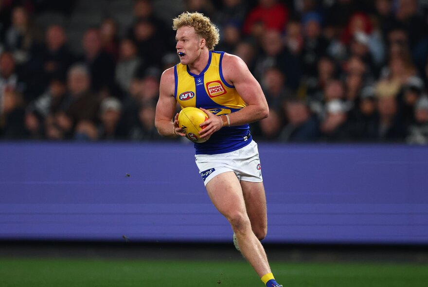 A West Coast Eagles player moves with the ball during a match. 