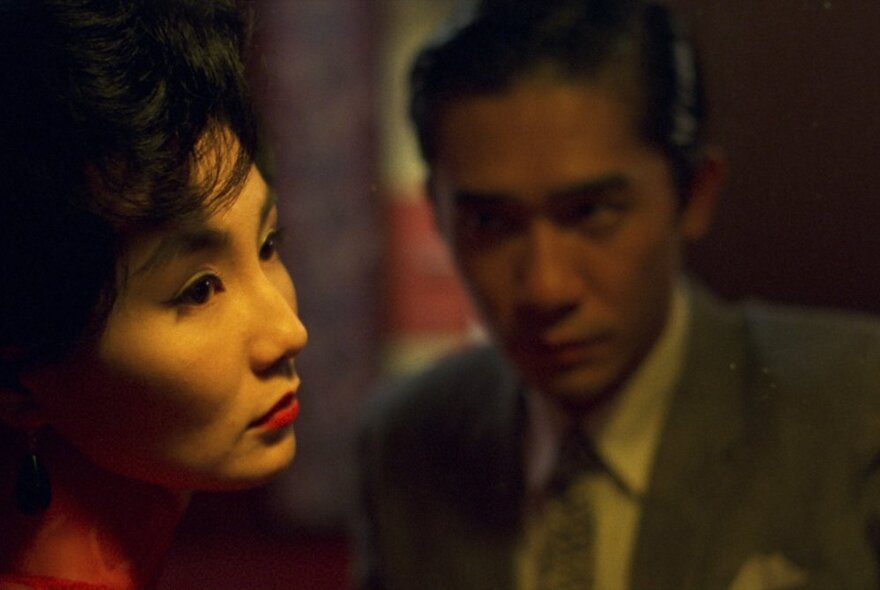 A still image from the film In the Mood For Love showing a woman turning away from a man wistfully.