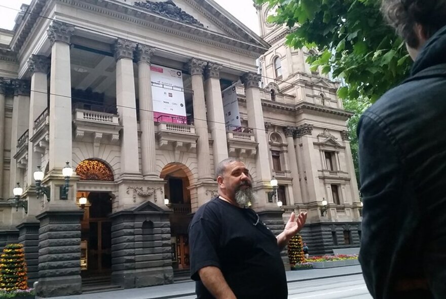 A man addressing someone outside the Melbourne Town Hall. 