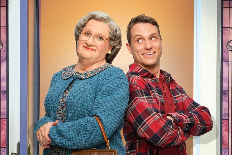 A scene from Mrs Doubtfire The Musical showing Mrs Doubtfire back-to-back with a man in a tartan shirt. 