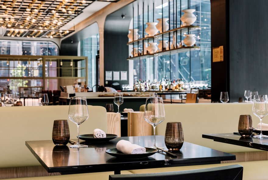 Interior of Miss Mi restaurant showing tables and chairs set for service, with floor to ceiling windows letting in much light.