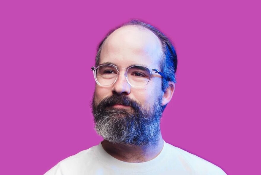 Smiling man with beard and glasses.