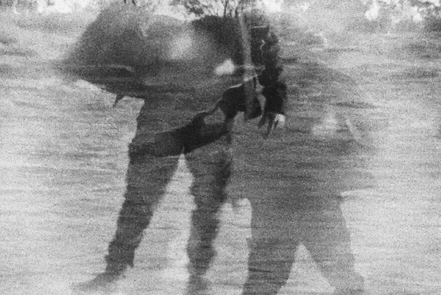Abstract and grainy overlayed image of people in black and white.