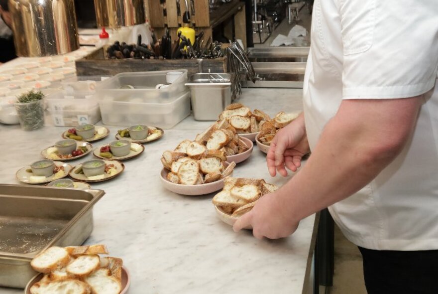 A chef preparing dishes on a bench.