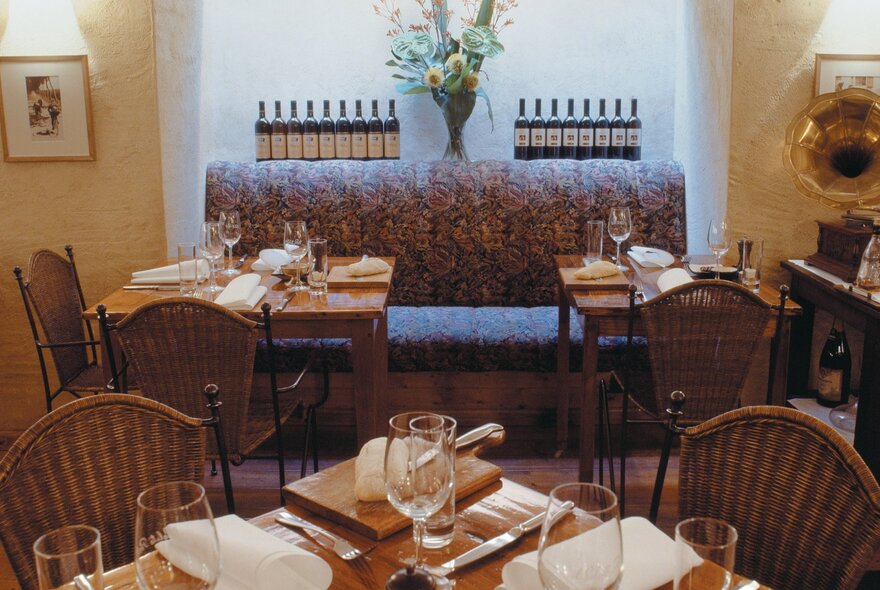 Interior of Il Solito Posto with a sofa-like banquette and small tables. 