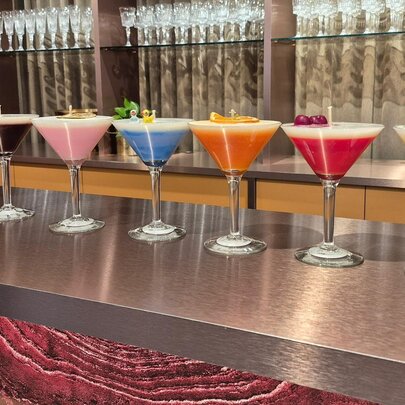 A line of martini glasses turned into colourful cocktail-inspired candles.