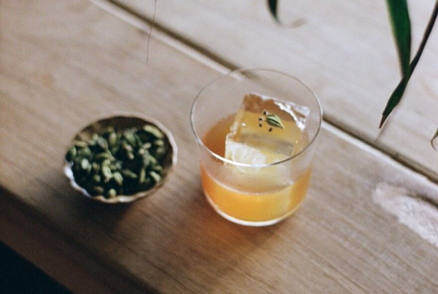 A cocktail with a small bowl of pepitas.