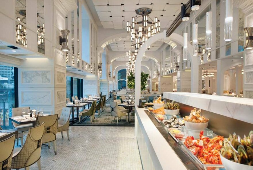 Interior of Conservatory at Crown, showing tables and seating and a buffet food selection.