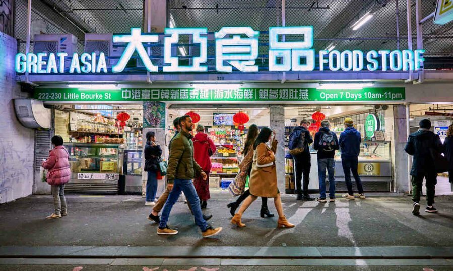 People walking past a chinese dlei at night