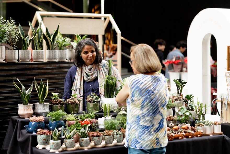 Customer and stallholder at a plant stall at an market.