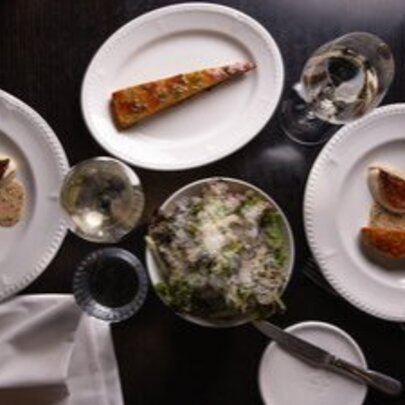 A selection of gourmet dishes arranged on a dark surface, seen from above.