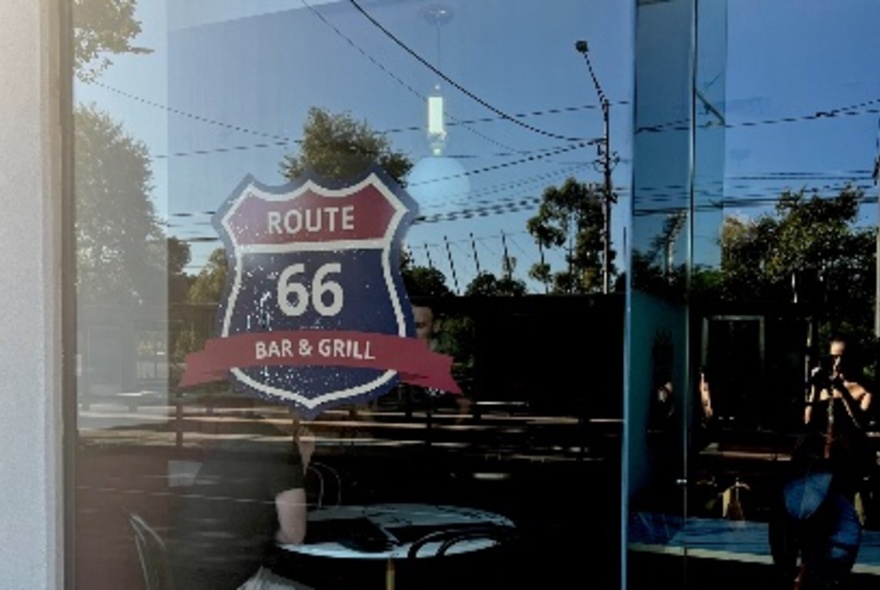 Cafe window with exterior reflections and internal signage.