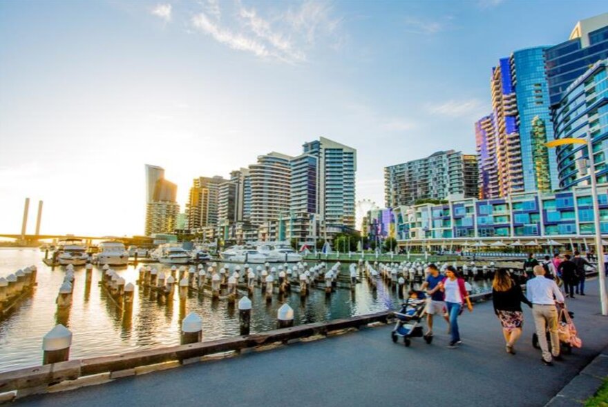 People walking along the water in the city.