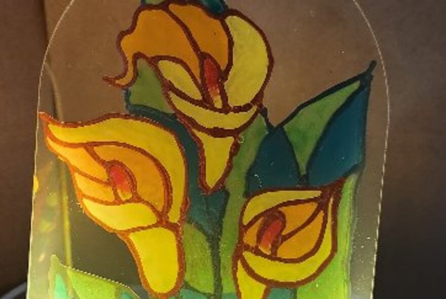 A close-up of a painted glass lamp with lillies on it. 