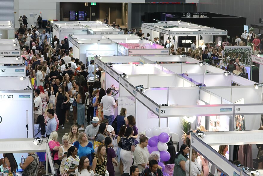 People walking around an expo centre looking at stalls and booths.