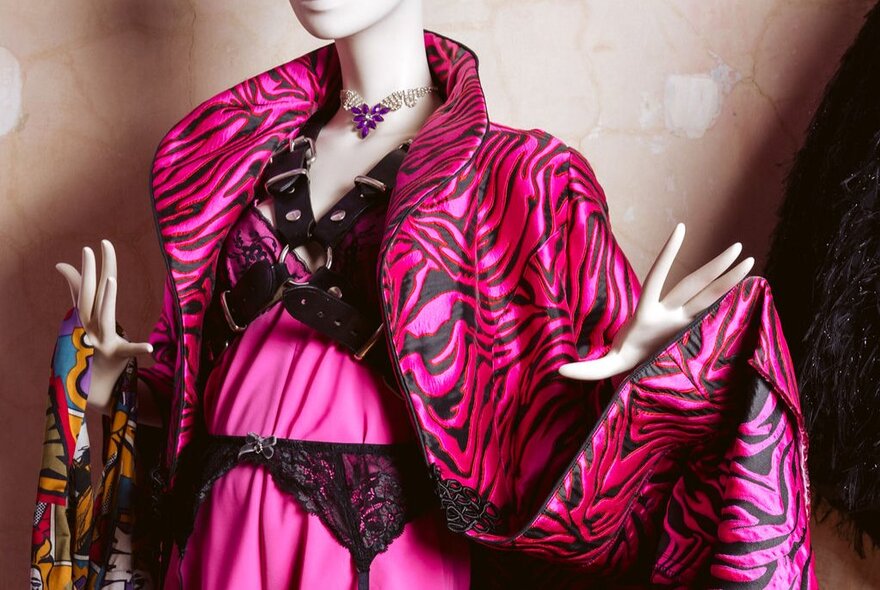 A female mannequin wearing a luxe pink and black tiger print silk jacket.