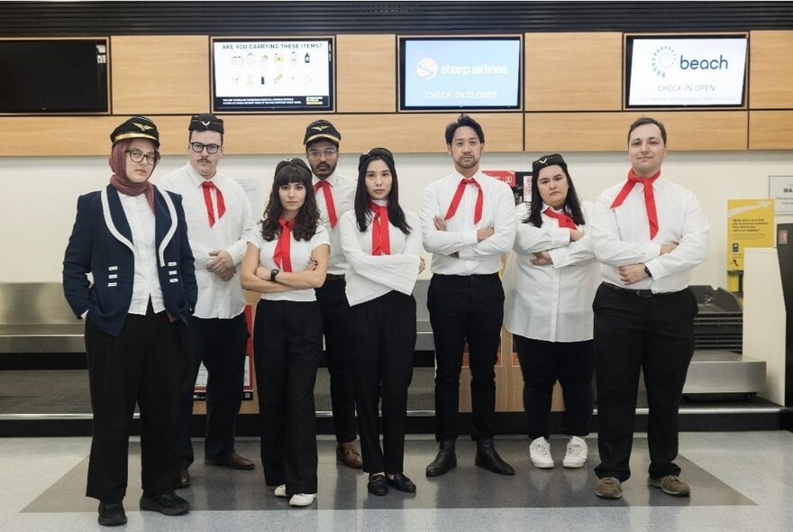A comedy group posing in uniform for a group shot as migration agents. 